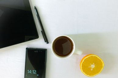 computer, phone, coffee on desk